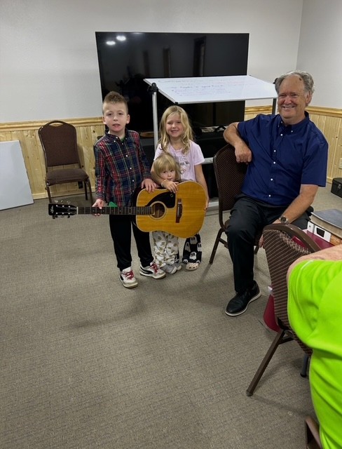 Kids with a guitar and smiling faces at church